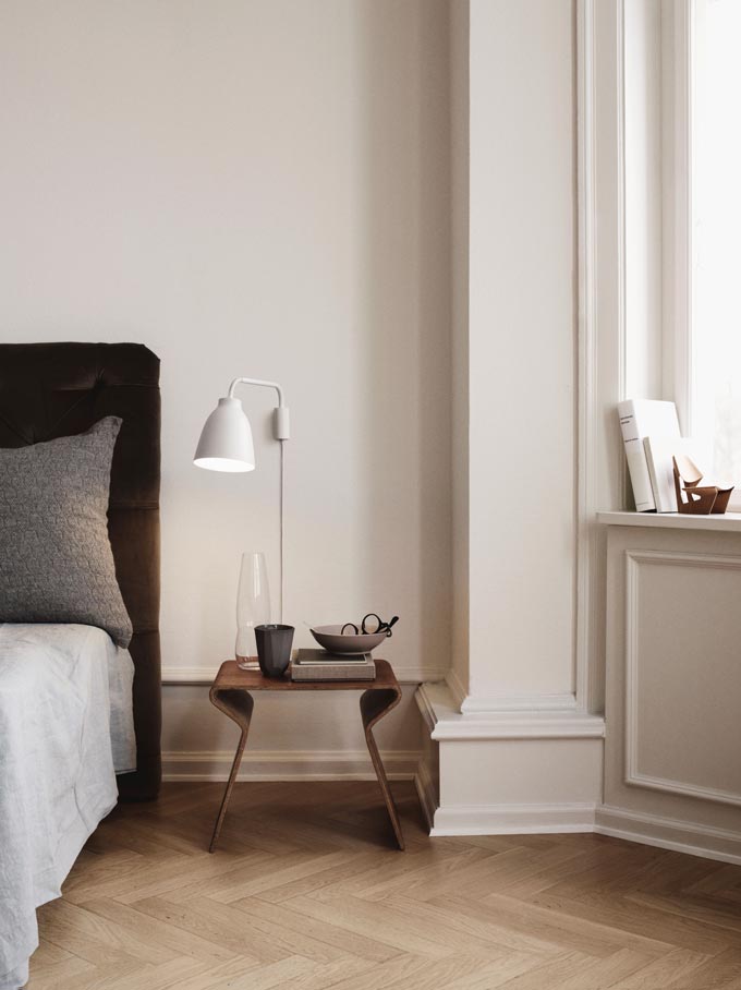 A Scandi chic bedroom featuring The Lightyears Caravaggio Read Wall Light. Image via Nest.co.uk.