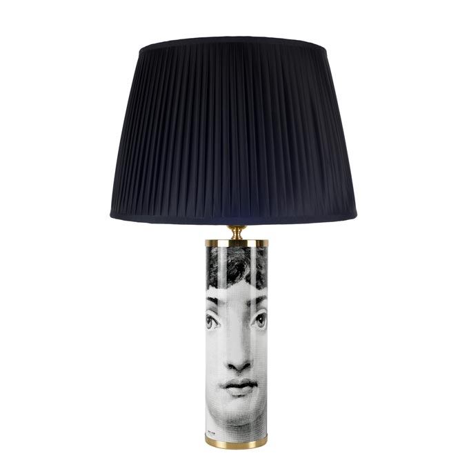 The Viso table lamp by Fornasetti with a conical black lampshade. Image via Mondoluce.