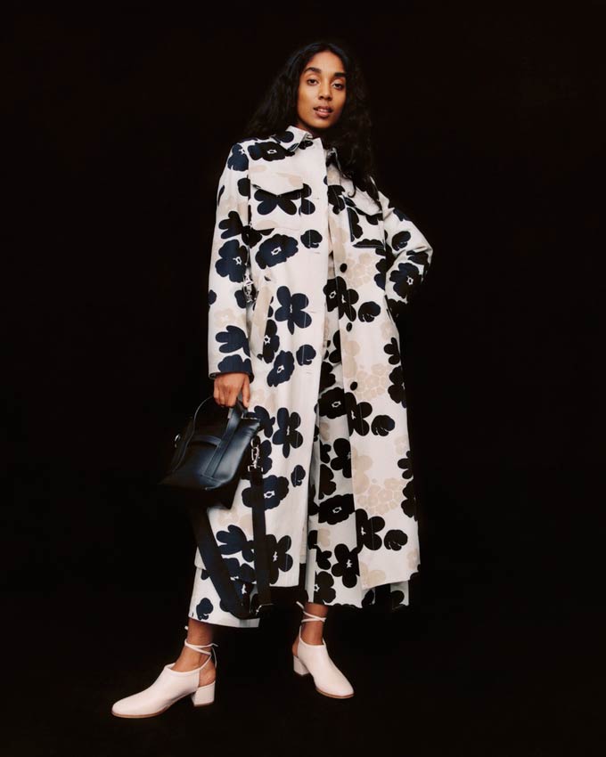 What a statement coat! A white overcoat with a black flower print paired with a black bag and white shoes. Image by Marimekko.