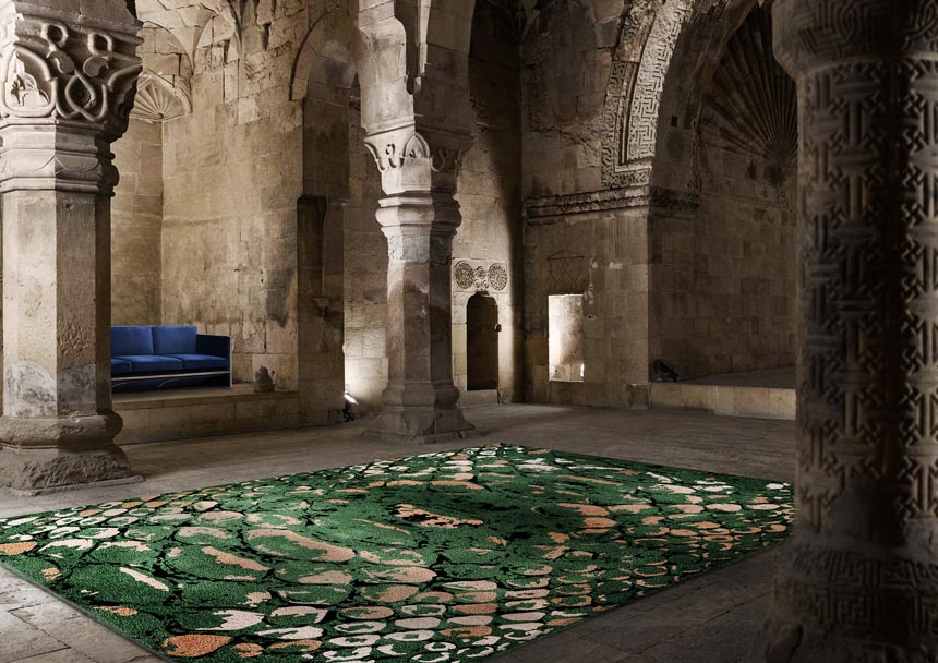 Jaw dropping rug! The green reptile pattern rug lays in the middle of an old monument with a blue sofa in between a wall recess. The neo-heritage trend is one of design trend that is on the rise for 2020.Image via Rug'Society.