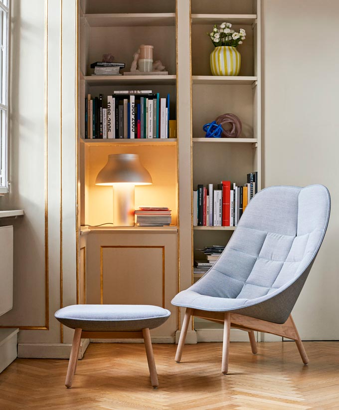 The Hay Uchiwa Lounge Chair and foot stool standing in front of a built-in bookcase with the Hay PC table lamp creating a cozy vignette. Image via Nest.co.uk.