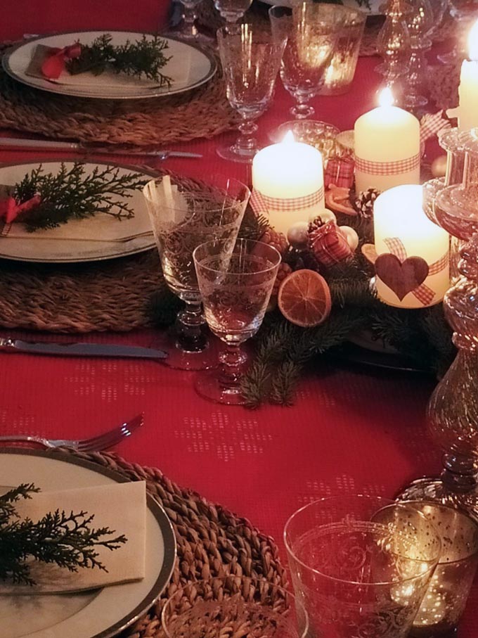 Close up of a table setting for Christmas with an Advent wreath as the centerpiece.