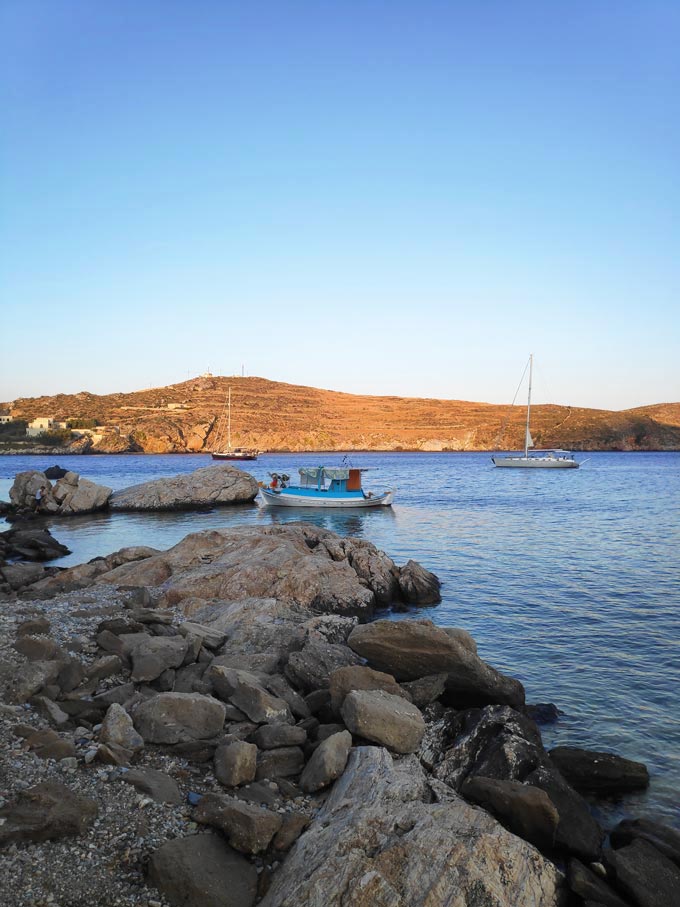 A seascape with two sailing boats and a fishing boat in Syros in portrait format.