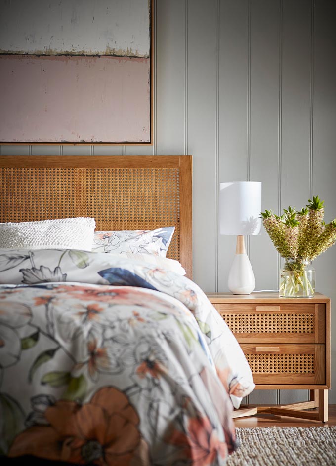 A chic bedroom with an organic vibe because of the cane bed headboard and the cane nightstand. Image: freedom.