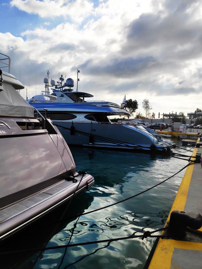 Yachts docked in a marina on a cloudy day.