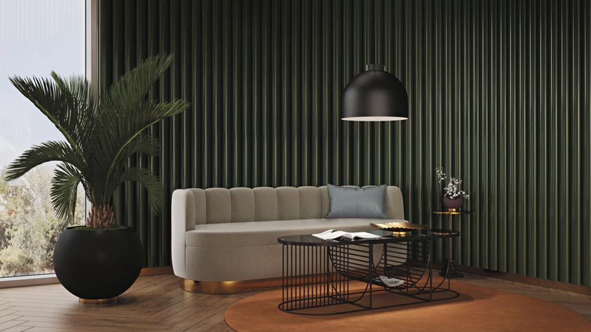 Decorating with intention: The AYTM Luceo round pendant light hanging over a sofa with a fluted back. A wired frame coffee table and a large plant pot fill in the setting against a dark fir green textured wall. Image via Nest.co.uk.