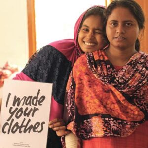 Two young women from India holding up a sign that reads 'I made your clothes.' Image: Secret Projects.