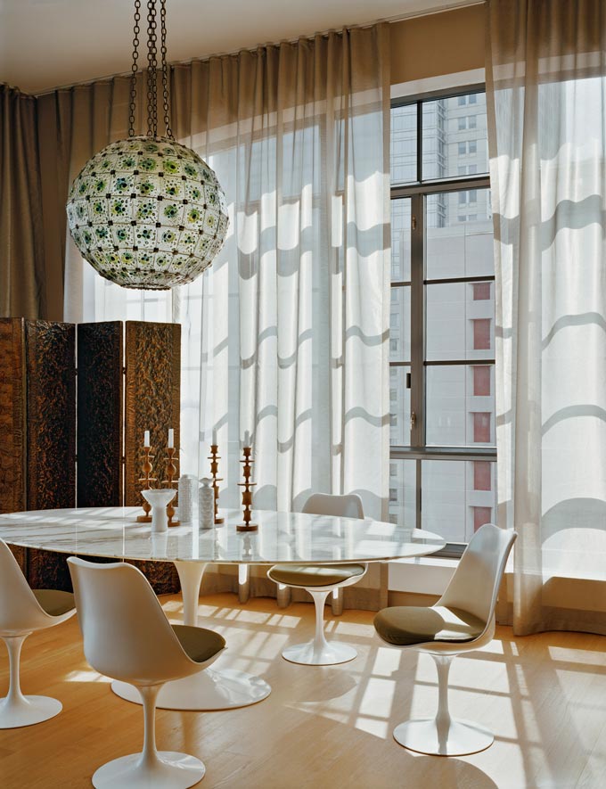 Decorating with intention. A bright dining space with the Saarinen tulip table and a large round statement pendant light. Image: Nest.co.uk.