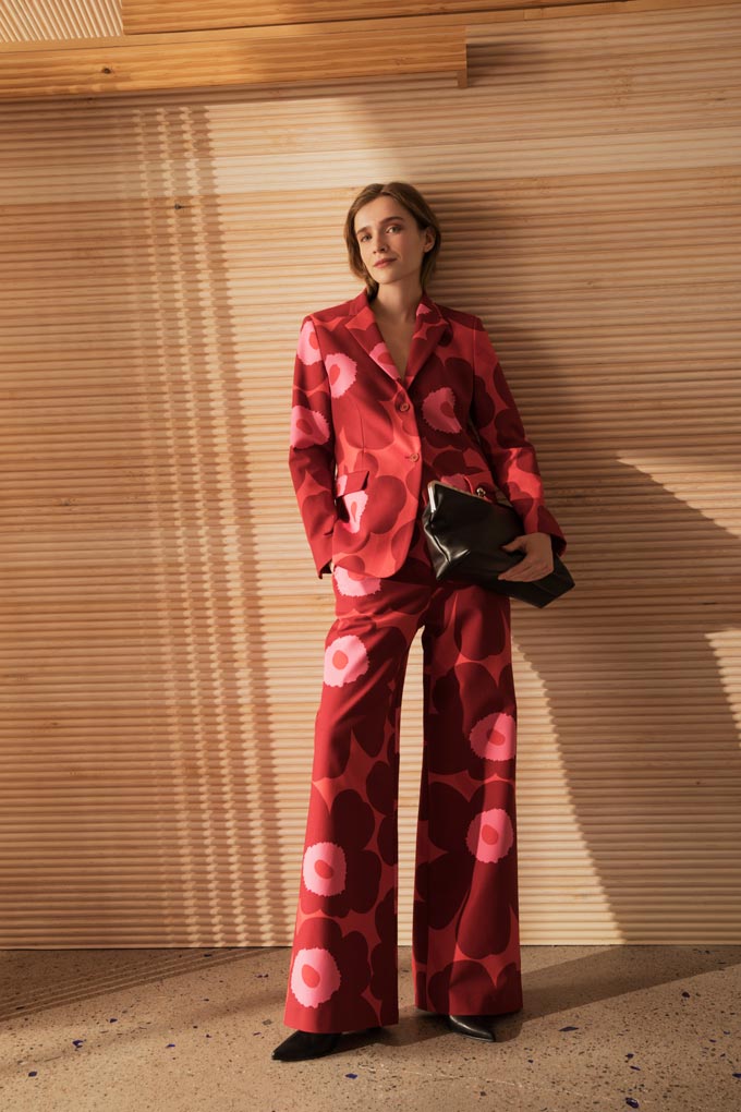 A stylish woman dressed in a bold red suite with an oversized flower print. Image: Marimekko.