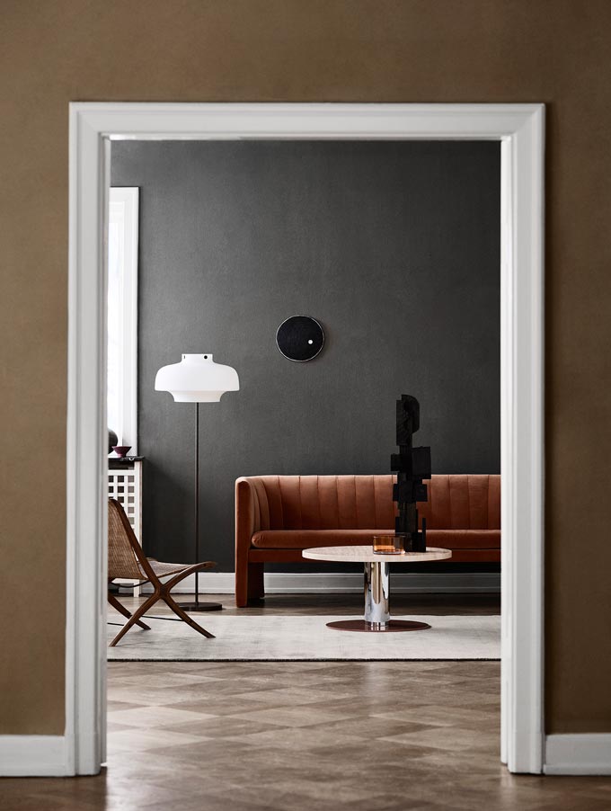 Peeping through a doorway into a contemporary minimal living room with earth tones. Image: Nest.co.uk.