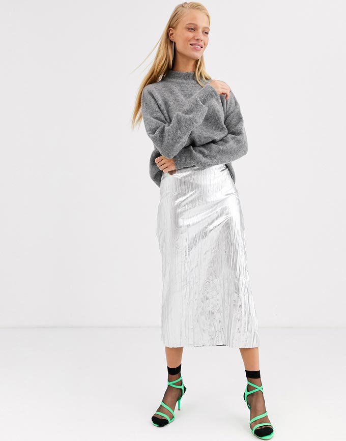 A woman wearing a grey sweater, a silver midi skirt, shear black ankle socks and neon green high heel sandals. Image: ASOS. A transitional winter to spring outfit idea.