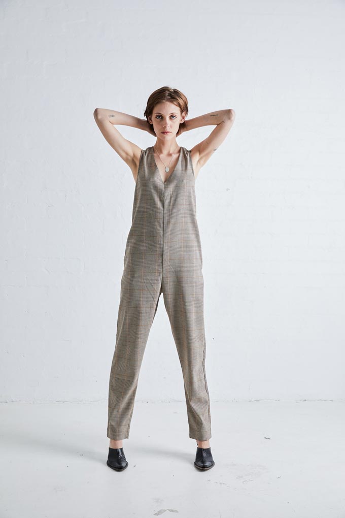 A jumpsuit with a plaid pattern paired with black mules. Image: NEUW Denim.
