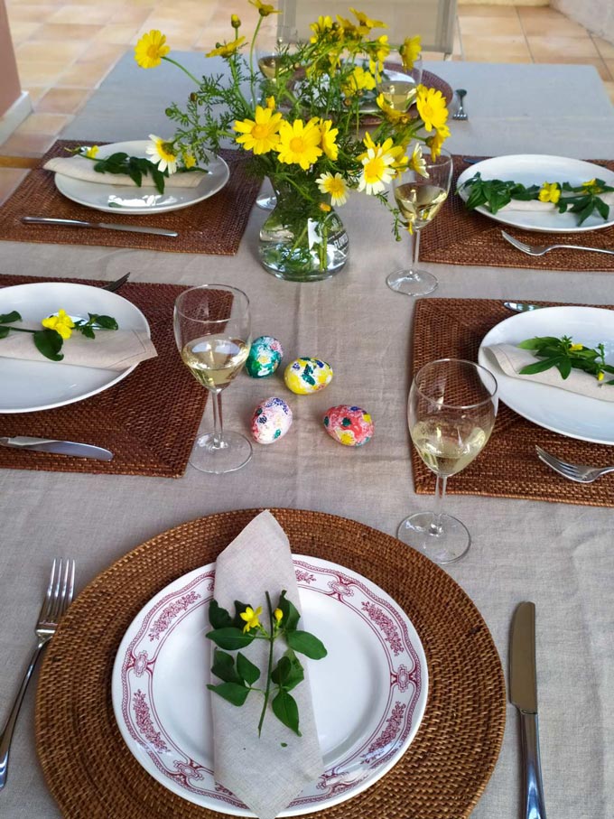 View of an Easter table setting with yellow daisies as a centerpiece.