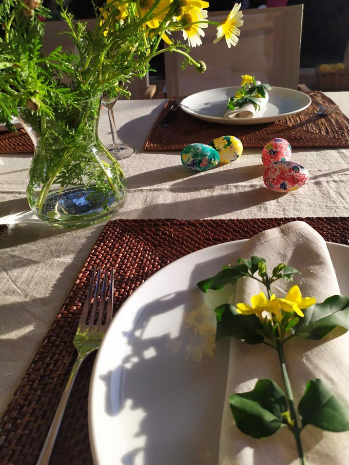 Detail view of an Easter table setting with yellow wildflowers.