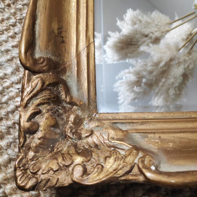 Detail view of a vintage gold gilded mirror with the reflection of Pampas grass.