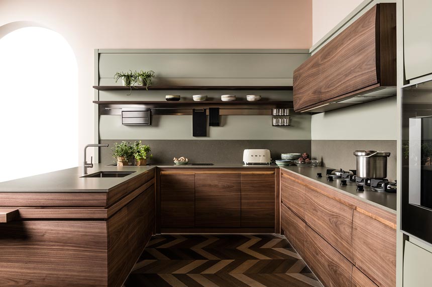 Side view of a stylish contemporary kitchen with green accents and dark stained veneer cabinetry. Image: Lottocento.