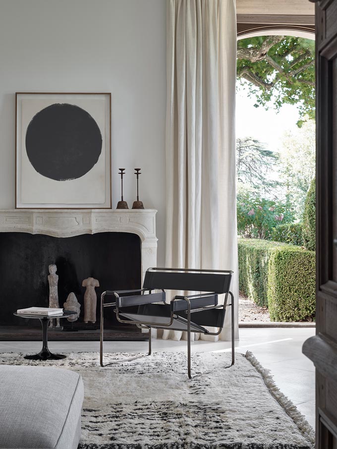 A black and white living room with a fireplace, featuring the Knoll Wassily chair. Image by Federico Cedrone for Chaplins Furniture.