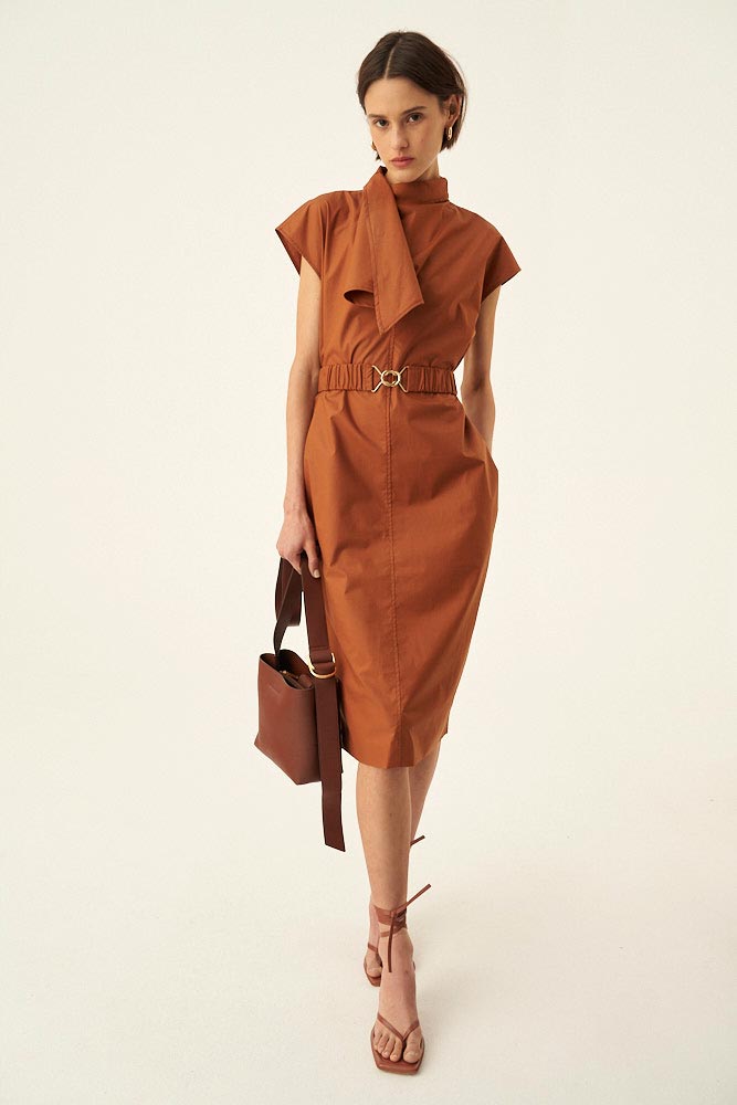 A stylish midi dress in a rusty hue paired with sandals and a handbag. Via Oroton.