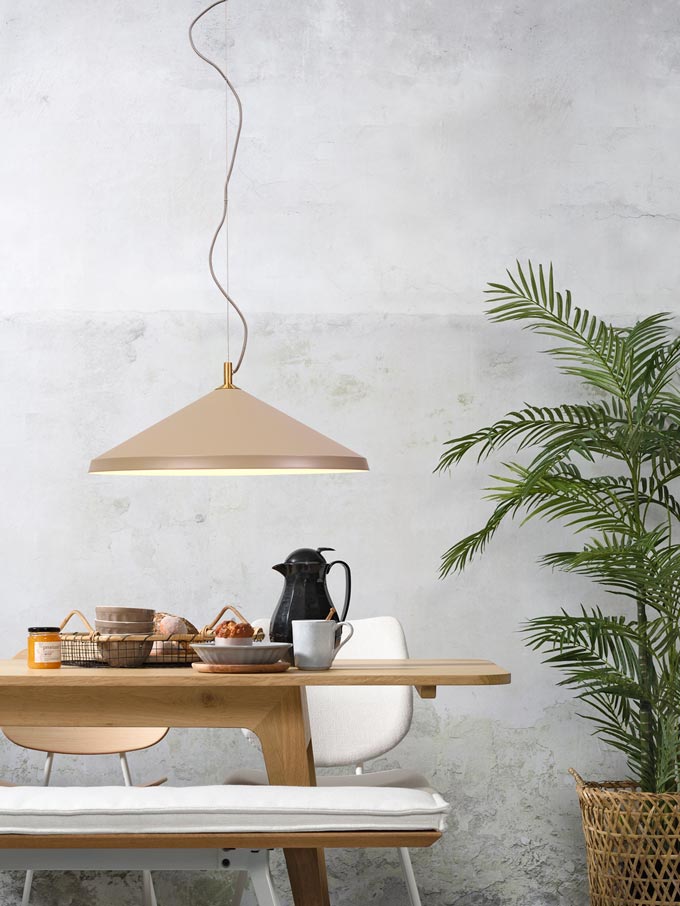 A beige pendant light over a wooden Scandinavian style dining table. Via Lime Lace.