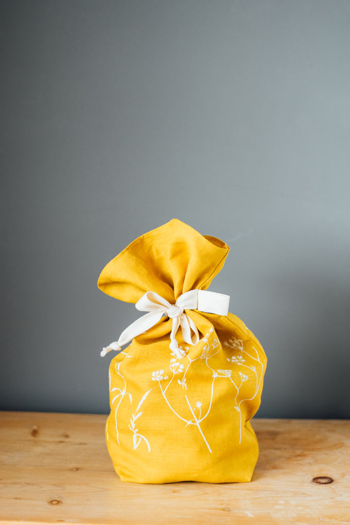 A yellow linen bread bag - another sustainable gift idea. Via Helen Round.