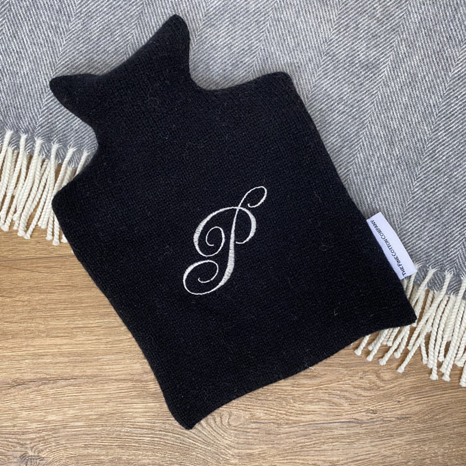 A monogrammed embroidered black hot water bottle with pure wool. Via The Fine Cotton Coompany.