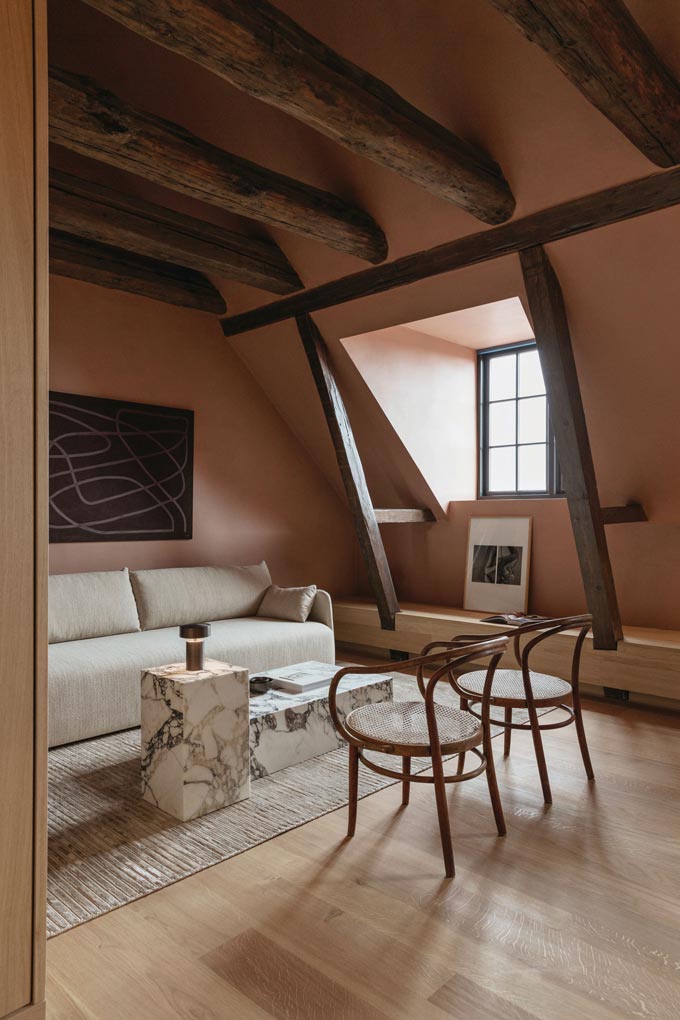 A warm toned loft space styled after the Japandi style, featuring an off white sofa from Menu and two marble cube like blocks for a coffee table. Via Nest.co.uk.