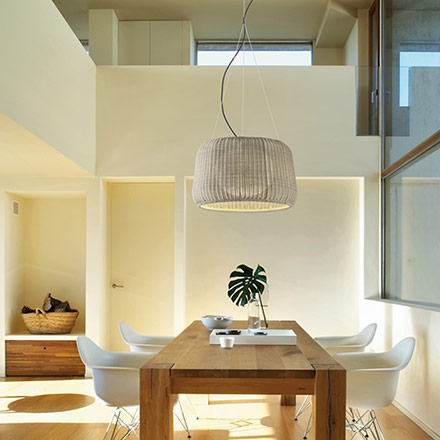 The Fora S suspension light by designers Alex Fernández Camps and Gonzalo Milà over a dining space flooded with plenty of natural light. Via Nedgis.