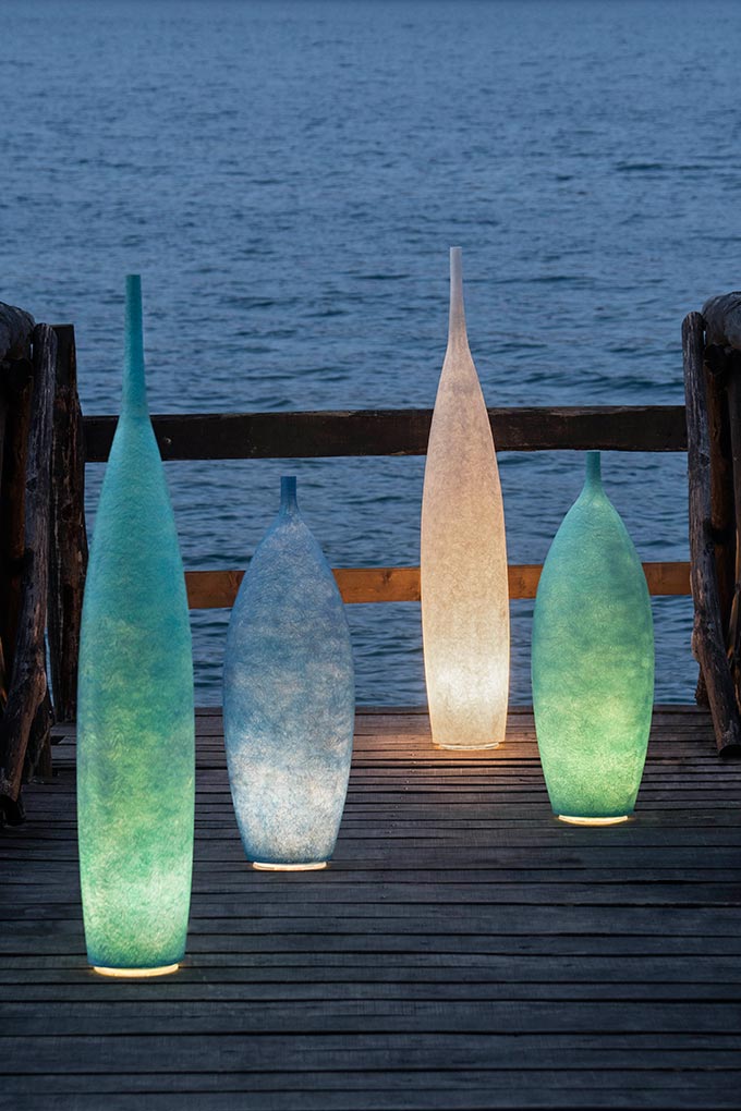 Swooning over: A lifestyle shot of outdoor floor lamps in the shape of large bottles in various shades. Via In-es.artdesign.