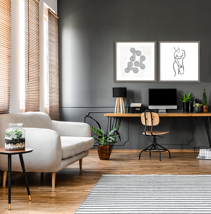 A contemporary space with a home office desk and a white sofa in front of three windows with Venetian blinds. Image: Abstract House.