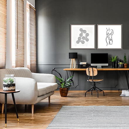 A contemporary space with a home office desk and a white sofa in front of three windows with Venetian blinds. Image: Abstract House.