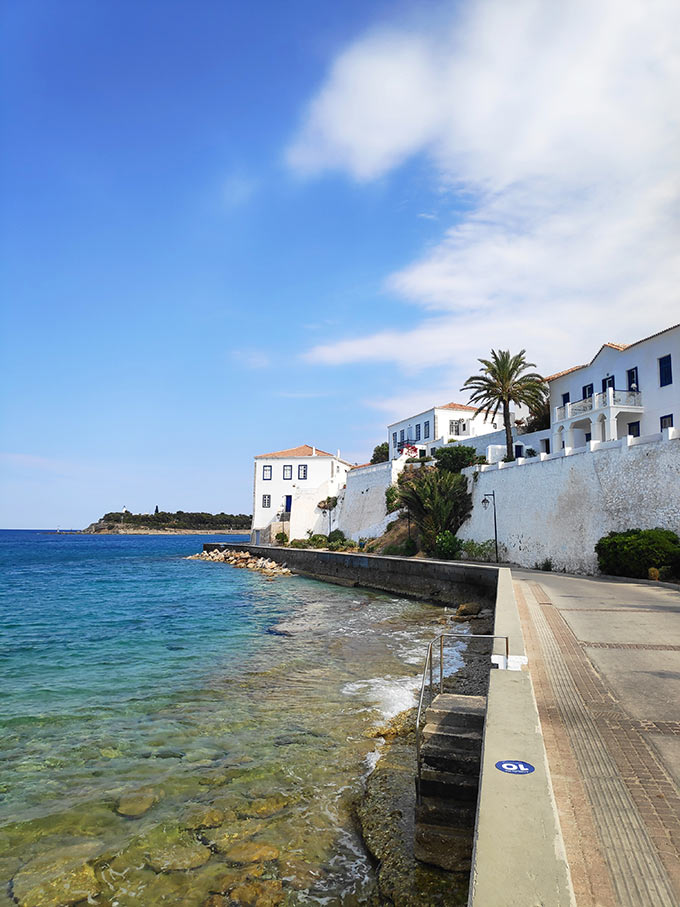 White houses along the shoreline of Spetses, Greece. Image: Velvet Karatzas.