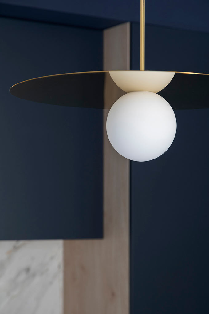 A close look at a brassy pendant light. Image: Elton Rocha for Culto.