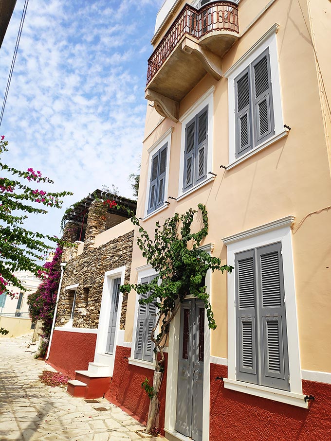 A building's facade in Hermoupolis with ochre and deep rusty hues.