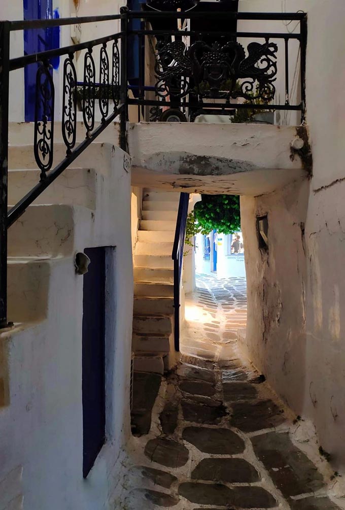 View of a narrow alley and stairs leading to entrydoors in Mykonos.