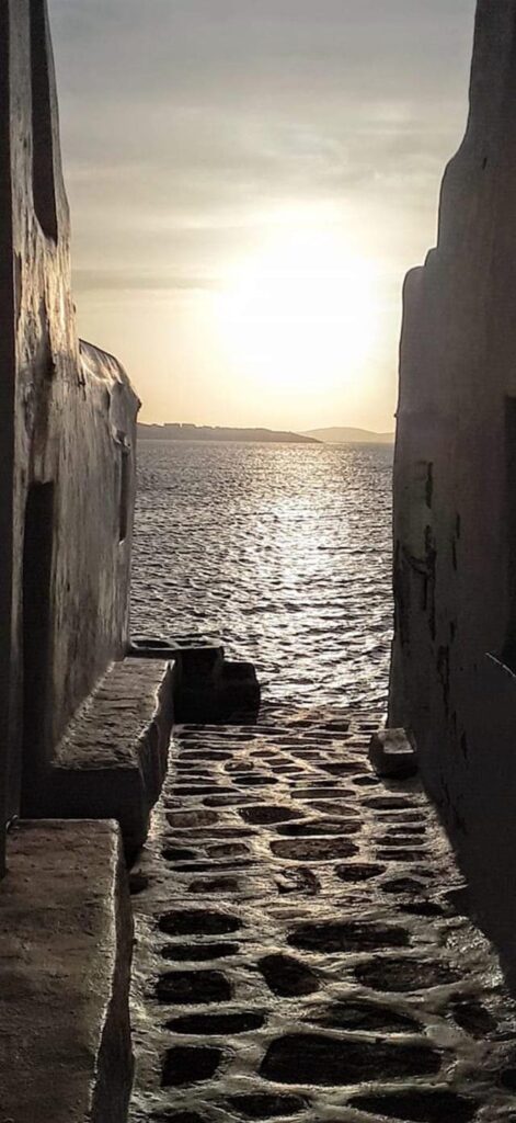 A stone paved narrow alley that leads to the seafront in Mykonos.