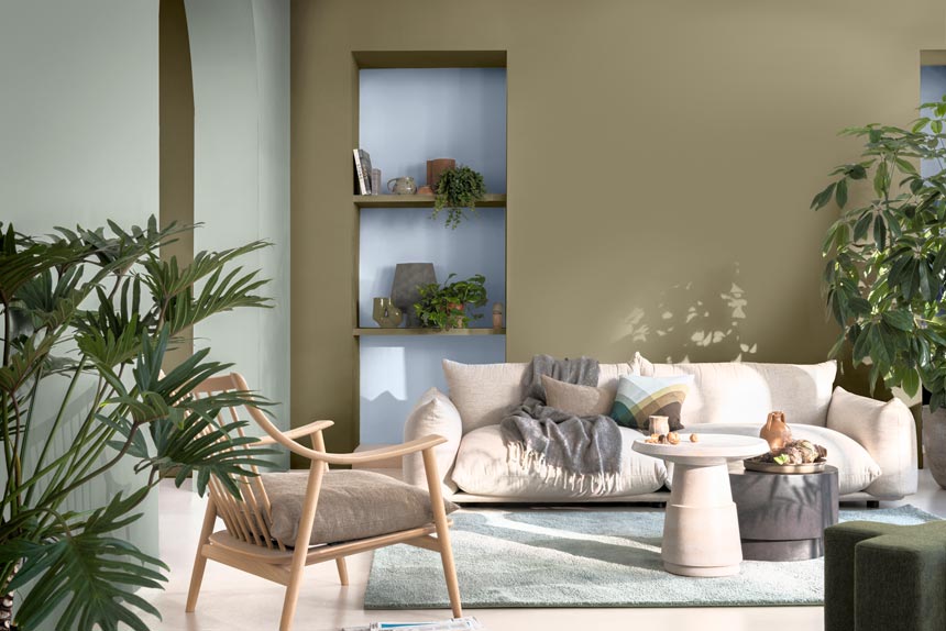 A contemporary sitting room with an off white sofa and a couple of recessed bookshelves at the rear of it featuring a light blue color - Dulux Bright Skies, Color of the Year 2022. Image credit: Dulux.