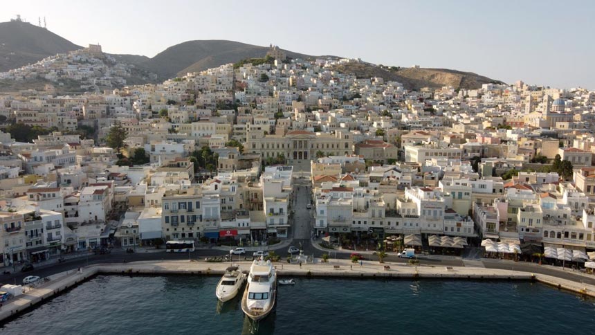 A drone pic of Hermoupolis in Syros, Greece from the port including the town hall. Image by author.