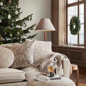 A stylish off white sitting room with a beautiful Christmas tree and wreath. Image: H&M Home.