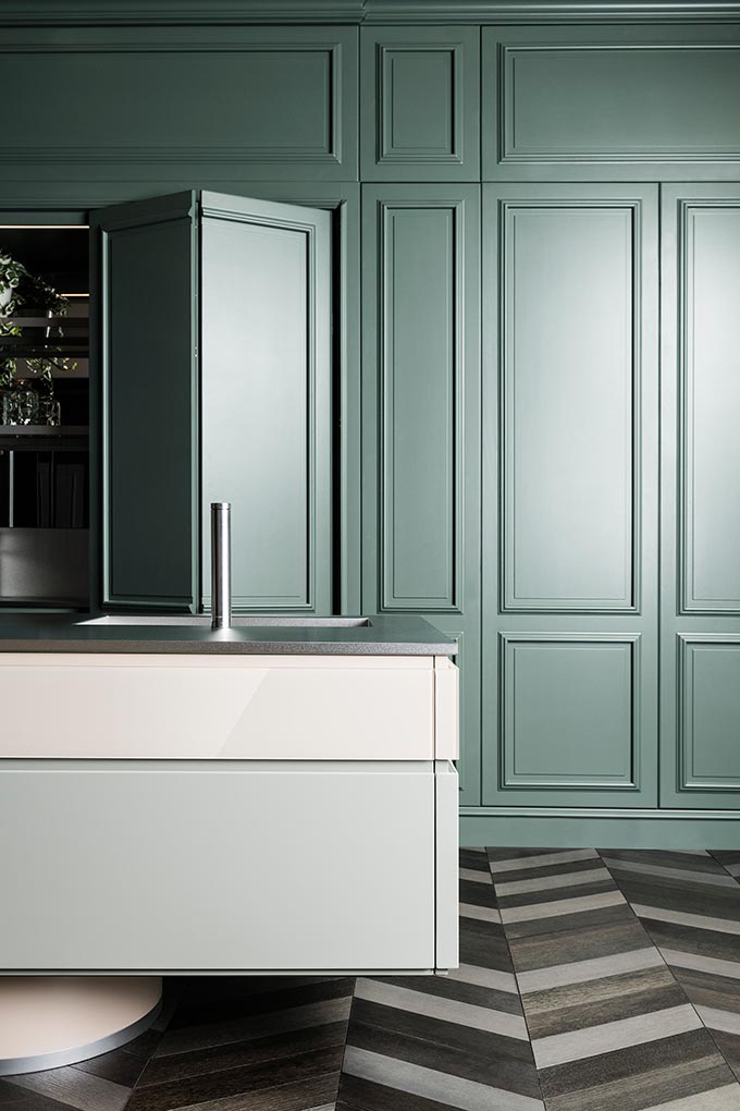 A stunning green wall paneling hiding away a fabulous kitchen unit. Image: L'Ottocento.