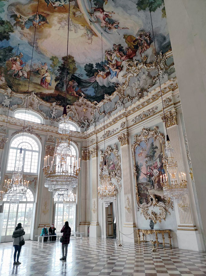 An opulent ceiling and wall murals decorating one of the many halls at the Nymphenburg Schloss.