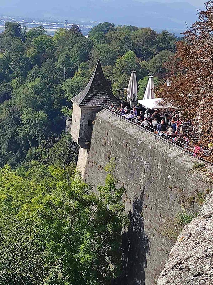 Partial view of a castle tower with its outdoor dining setup in Salzburg, Austria.