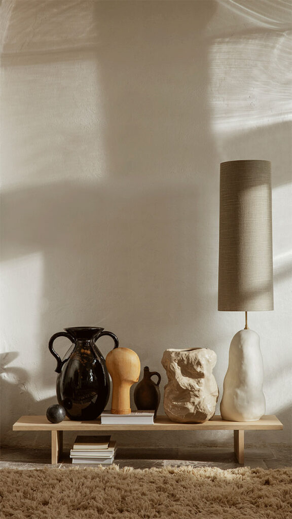 A lifestyle shot of several decor pieces including a table lamp, with a strong texture to them. Image: fermLIVING.