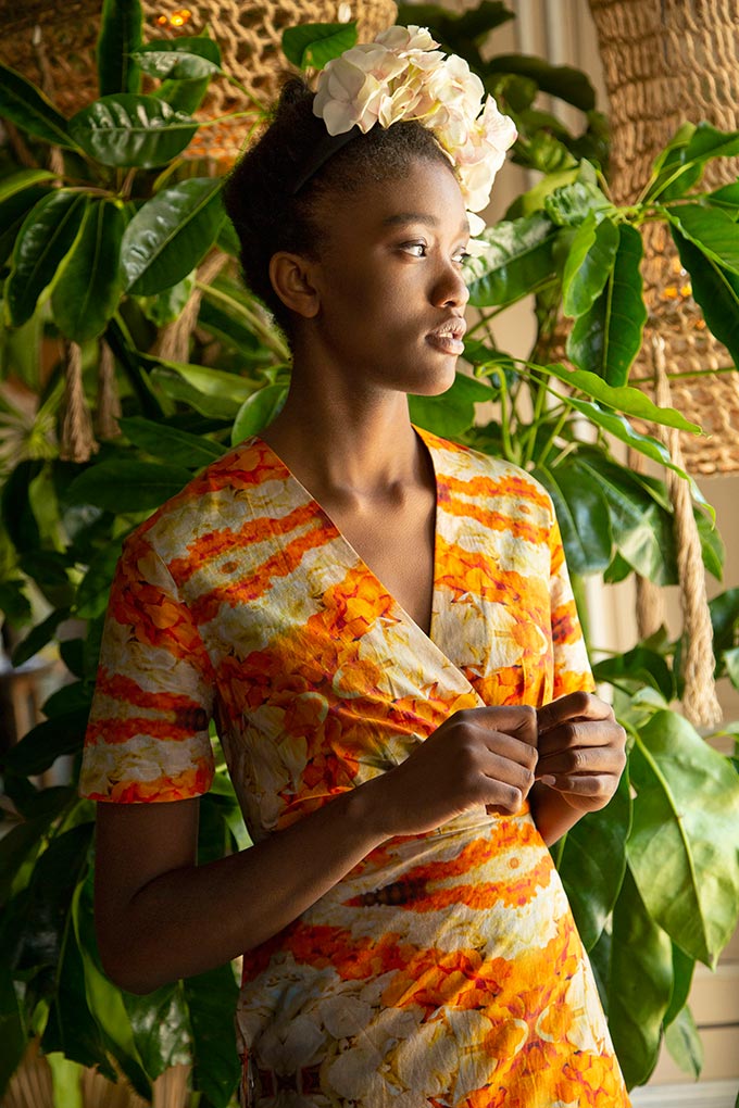 A woman dressed in a spring dress with orange and yellow prints. Image: Pam Weinstock.