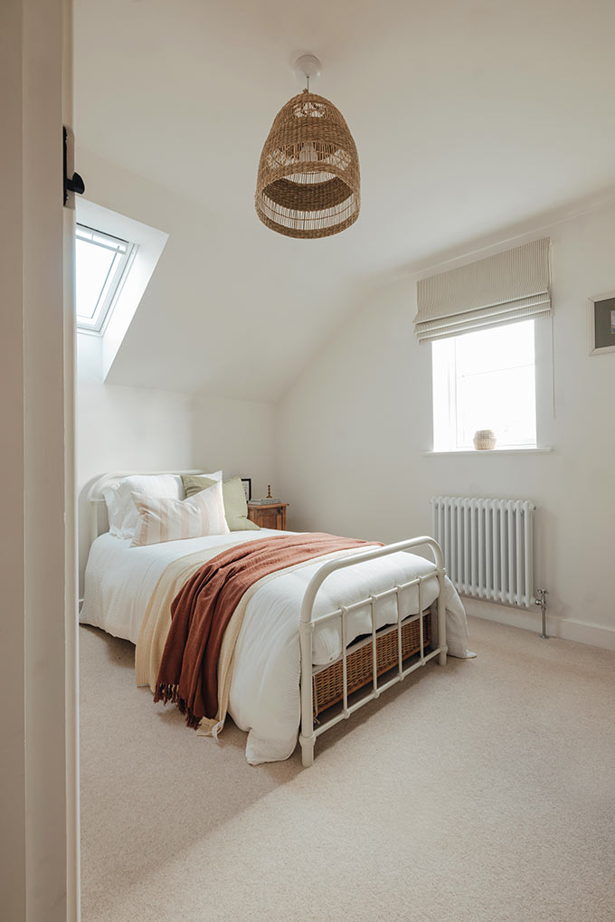 A beautiful and serene bedroom with an organic vibe and a Roman shade hanging from the side window. Image: Stitched.co.uk.
