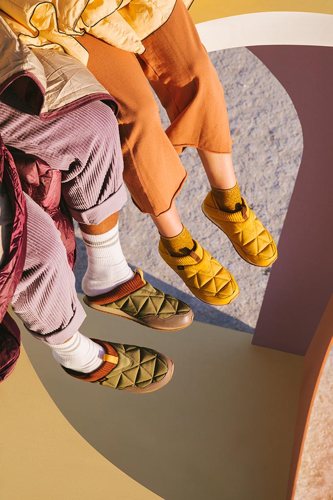 Two people's legs featuring Teva trainers and slippers in bright colors. Image: Teva.