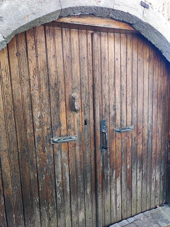 A picture of a wooden door with a traditional hand door knock.