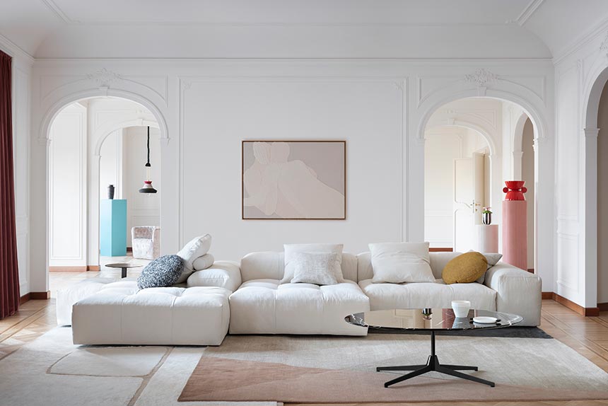 A stylish white sitting room with a few color accents here and there featuring a white sectional sofa and a gorgeous black veined marble top coffee table the Saba Italia Hexa. Image: Nest.co.uk.