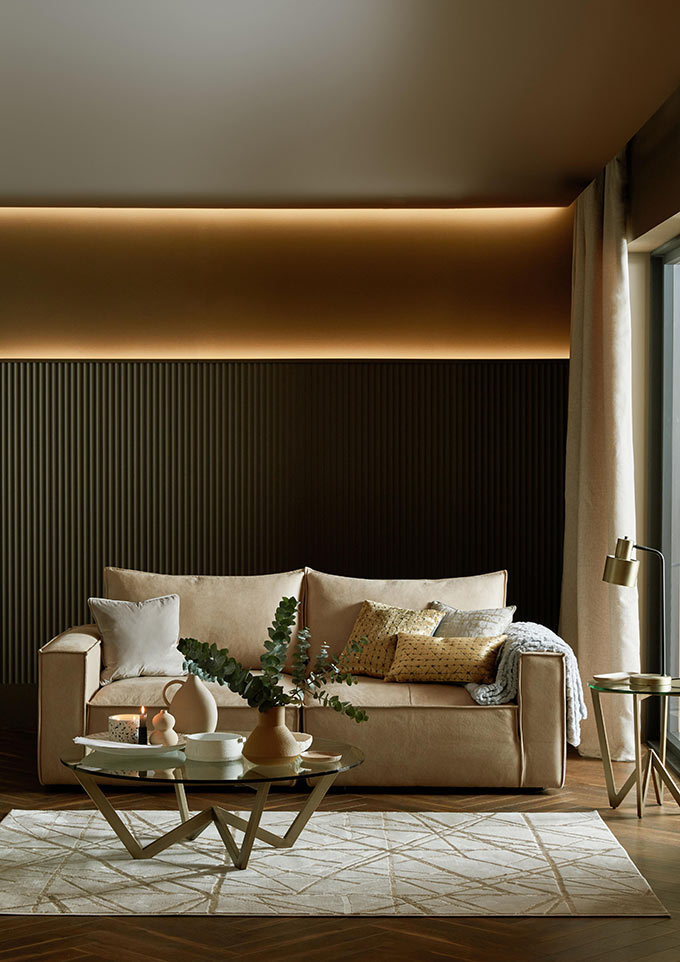 A stylish contemporary sitting room with an off white sofa next to a door window with a curtain. Image: Sofology.