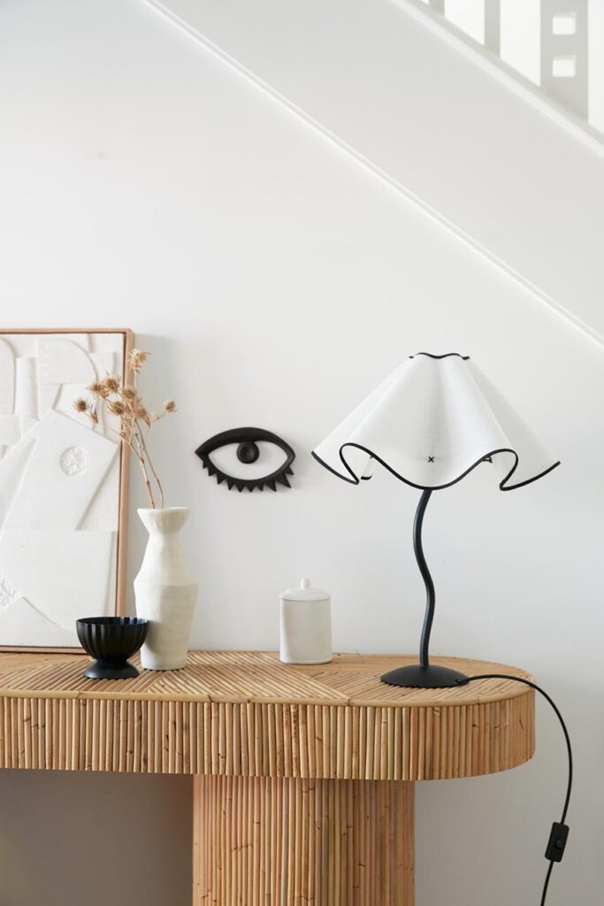 Love this Theodore lamp with its 3D curvy shade in ivory standing on a textured console table. Image: Merci Maison.