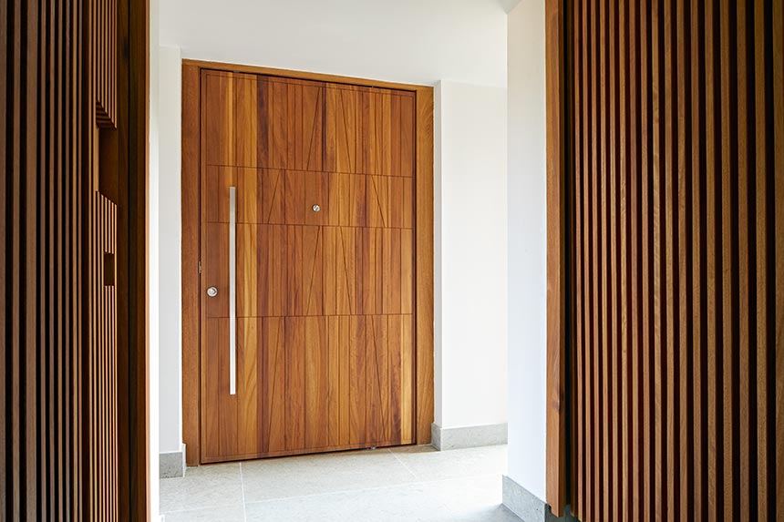 A beautiful front door in iroko and ridged textured wall panelling on the corridors. Image: Urban Front.